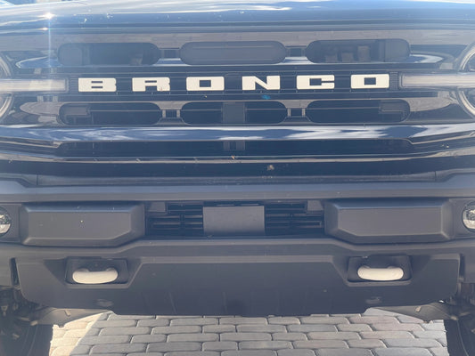 6th generation Ford Bronco with White tow hook covers.